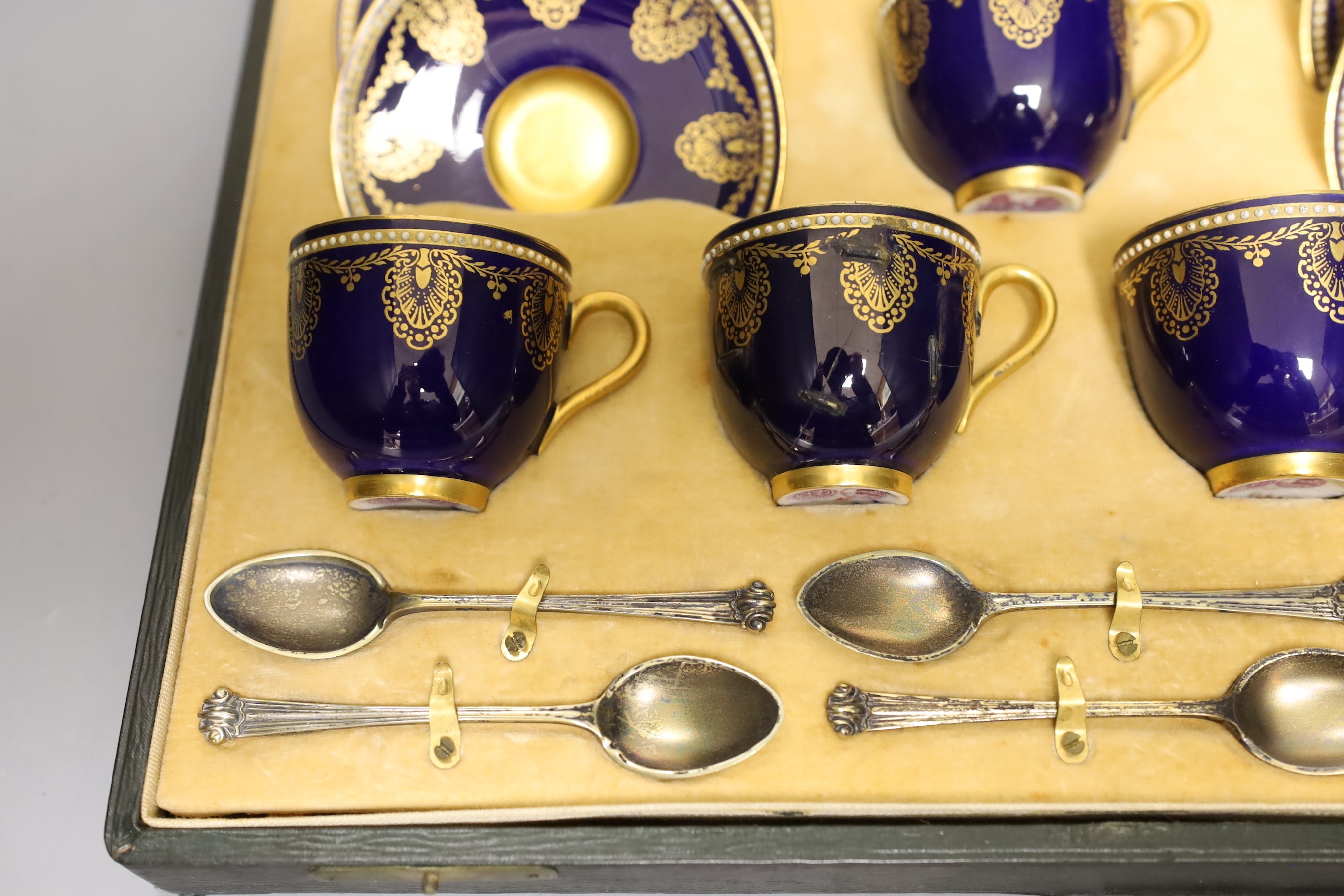 Boxed Royal Worcester blue coffee set with gilt stylised shell and swag design together with six silver coffee spoons; C899 and 6683